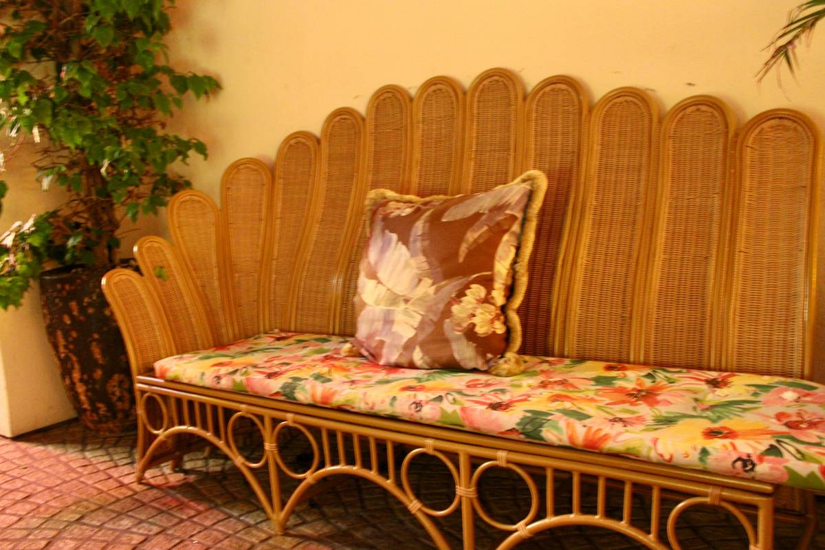Floral print small love seat in a compact city apartment with neutral walls, wooden coffee table, and potted plants—demonstrating scale and cohesion